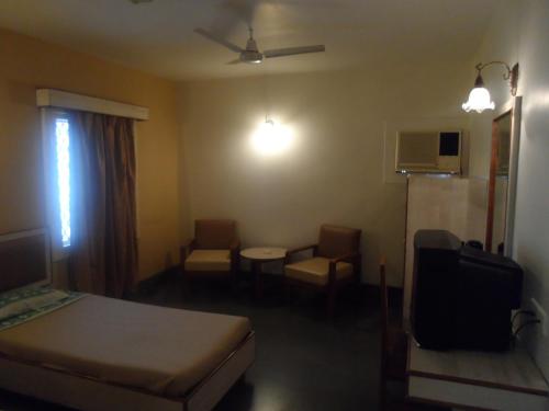 a hotel room with a bed and a table and chairs at Shanthiniketan - Ramoji Film City in Pedda Ambarpet