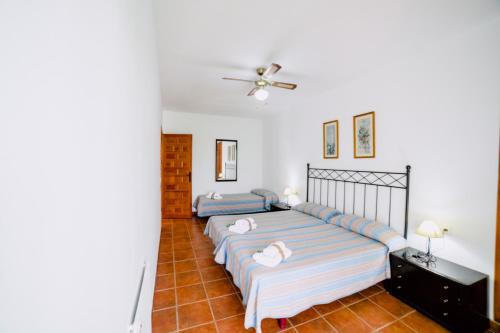 ein Schlafzimmer mit zwei Betten und einem Deckenventilator in der Unterkunft Casa Rural San Antonio in Cabra