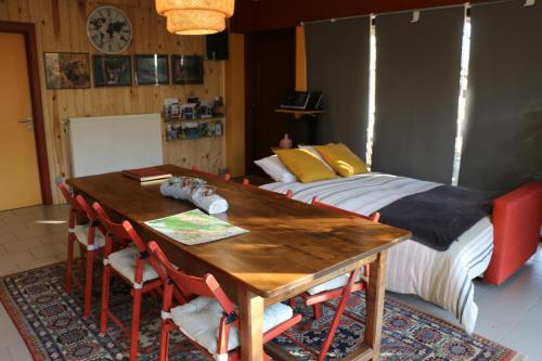 uma sala de jantar com uma mesa e uma cama em Gesves Côté Jardin em Gesves