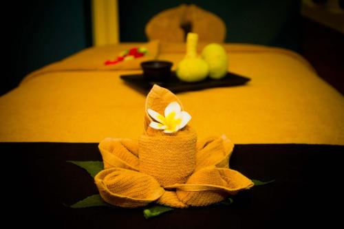 a yellow flower sitting on top of a bed at Radisson Blu Poste Lafayette Resort & Spa (Adults Only) in Poste Lafayette