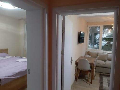 a room with a bed and a table and a couch at Апартамент Артемида in Pravets