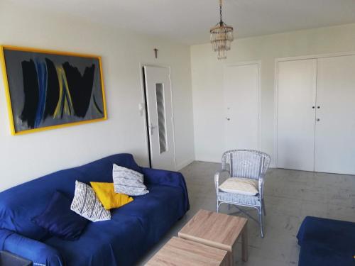 a living room with a blue couch and a chair at La Fontaine, F2 au cœur de Paray in Paray-le-Monial