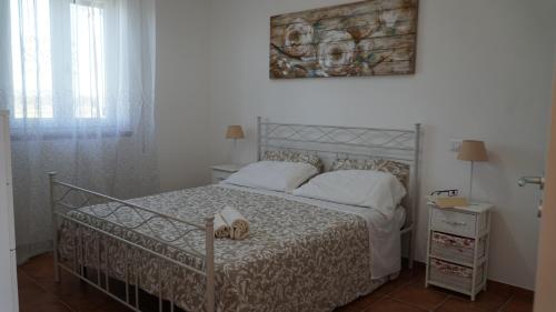 una camera con un letto bianco e una foto a parete di Home sweet Home a Metaponto