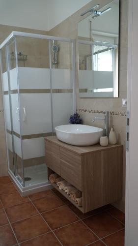 uma casa de banho com um lavatório e uma cabina de duche em vidro. em Home sweet Home em Metaponto
