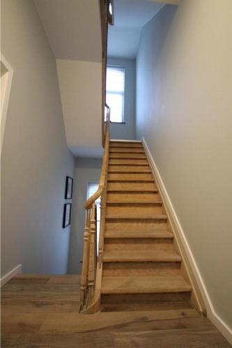 a staircase in a room with wooden floors at Boonuz guesthouse, luxe duplex vakantiehuis in centrum Ieper met privé lounge terras en IR sauna in Ypres