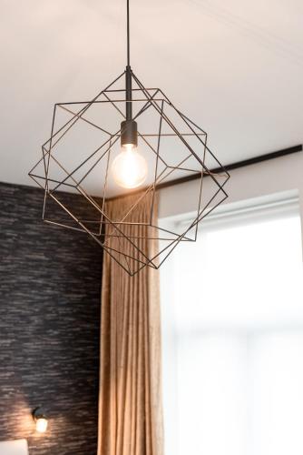a light hanging from a ceiling with a curtain at Boonuz guesthouse, luxe duplex vakantiehuis in centrum Ieper met privé lounge terras en IR sauna in Ypres