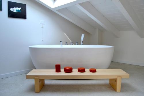 La salle de bains est pourvue d'une baignoire et d'une table avec deux bougies rouges. dans l'établissement zen AR holiday-home, à Peschiera del Garda