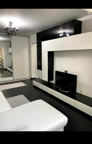 a living room with a white couch and a mirror at Apartament Nicolas in Brezoi