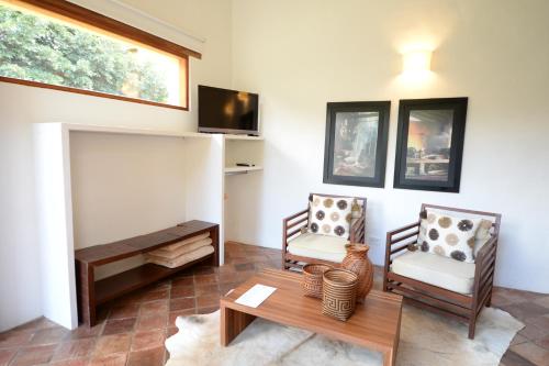 a living room with two chairs and a table at Hotel Casa Terra in Villa de Leyva