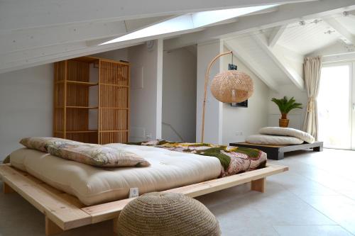 duże łóżko na drewnianej platformie w pokoju w obiekcie zen AR holiday-home w mieście Peschiera del Garda