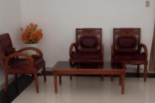 um grupo de três cadeiras e uma mesa em Green House Syariah Mitra RedDoorz em Rantauprapat