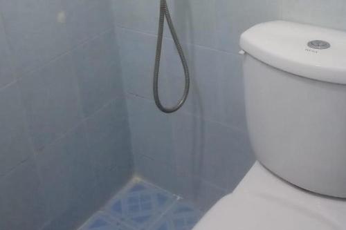 uma casa de banho com um WC branco e um chuveiro em Green House Syariah Mitra RedDoorz em Rantauprapat