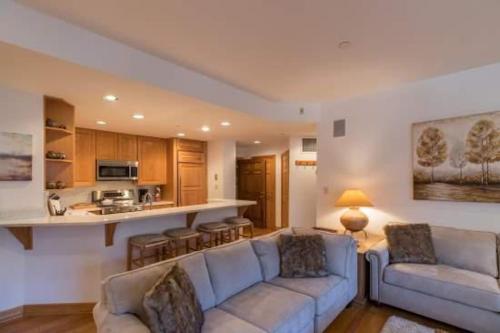 a living room with two couches and a kitchen at Strawberry Park Ski In Ski Out Condo in Beaver Creek
