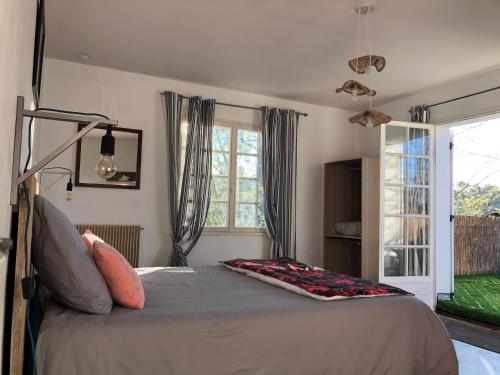 a bedroom with a bed and a window at Chambres d'Elisa in Saint-Morillon