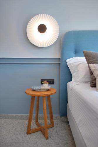 a small table next to a bed and a mirror at Charisma Boutique Hotel in Parga