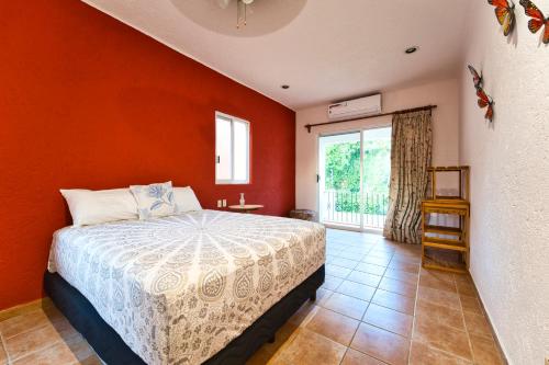 a bedroom with a bed with an orange wall at Tata & Nana’s Home - 3Bdrm Private House in Cancún