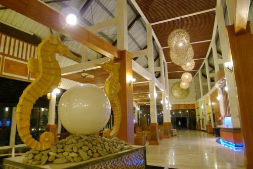 a lobby with a statue of a horse and a ball at Pearl Laguna Resort in Myeik
