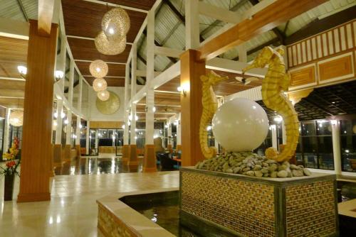 a lobby with a dragon statue in the middle of a building at Pearl Laguna Resort in Myeik