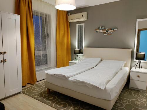 a bedroom with a white bed and a window at Avo Apartments in Olimp