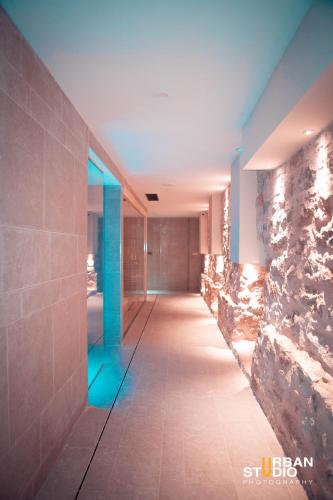 a hallway with a stone wall and blue lights at Spa & Wellness by Des Anglais " Accesso SPA compreso" in Sanremo