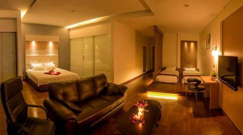 a hotel room with a bed and a couch at Avantgarde Hotel in Skudai