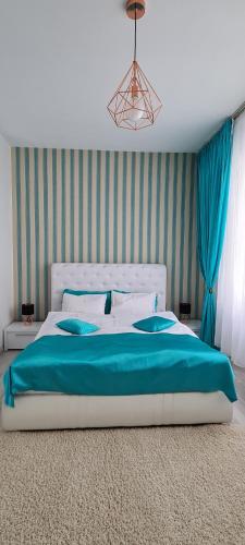 um quarto com uma cama grande e um cobertor azul em Apartament Blue Sea em Mamaia Nord – Năvodari