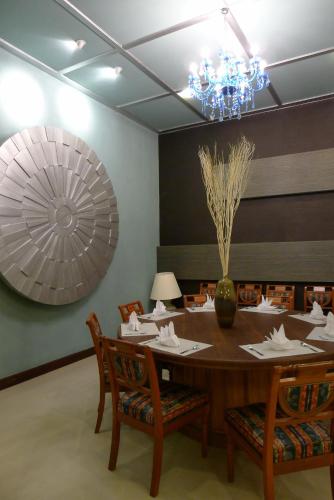 a dining room with a table with chairs and a chandelier at Pearl Laguna Resort in Myeik
