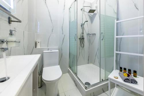 a white bathroom with a shower and a toilet at Comfort Stay Athens Airport Hotel - FREE shuttle from and to the airport in Spáta