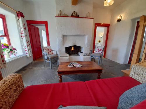 a living room with a couch and a fireplace at Donegal Thatched Cottage in Loughanure