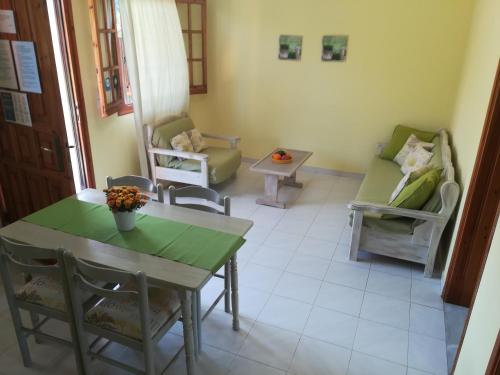 a living room with a table and chairs at Olga's Garden Apartments in Almiros Beach