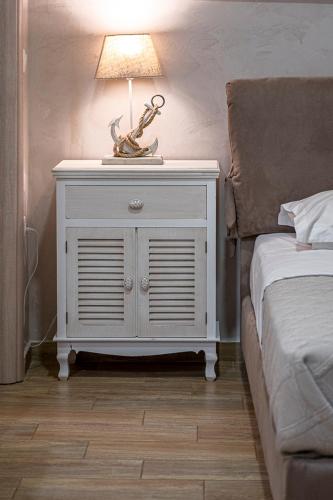 a white nightstand with a lamp on it next to a bed at Comfort Stay Athens Airport Hotel - FREE shuttle from and to the airport in Spáta