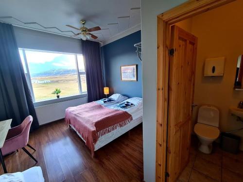 a bedroom with a bed and a window at Hlín Guesthouse in Varmahlid