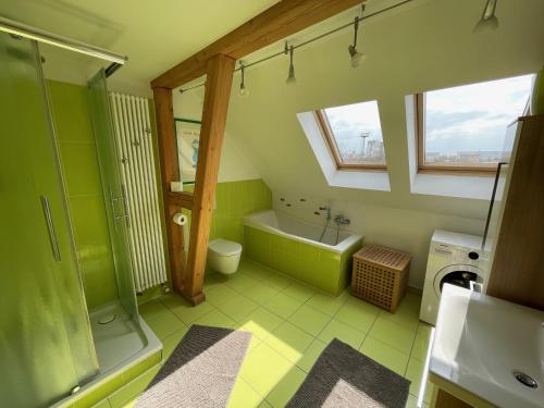 a green bathroom with a tub and a toilet and a sink at Maisonette Salzknecht in Halle an der Saale