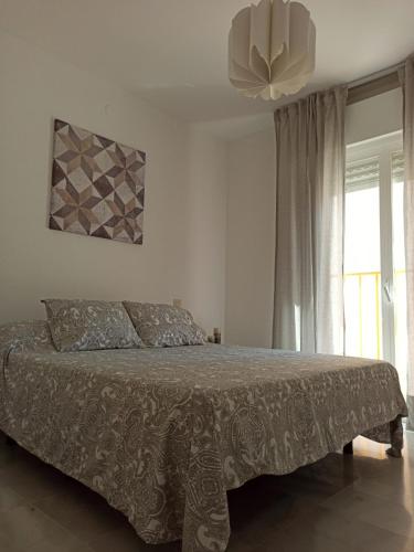 a bedroom with a bed and a large window at Apartamento la Noria 2 Playa in San Luis de Sabinillas