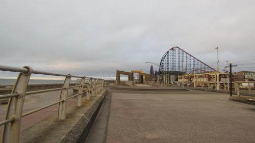 a roller coaster on a pier next to the beach at The Scala Hotel in Blackpool