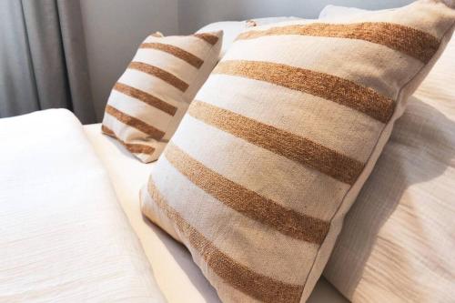 - 2 oreillers marron et blanc sur un lit dans l'établissement Cabine d'O - Nieuw appartement dichtbij zee!, à Ostende
