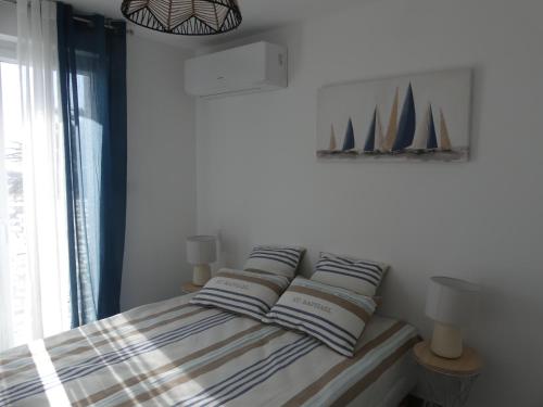 ein Schlafzimmer mit einem Bett mit drei Segeln an der Wand in der Unterkunft VILLA GEORGES in Le Grau-du-Roi