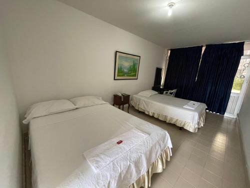a bedroom with two beds and a window at Hotel Luna Roja del Llano in Yopal