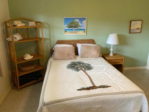 a bedroom with a bed with a palm tree on it at Pelican Cove Condo in Christiansted