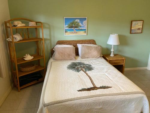 ein Schlafzimmer mit einem Bett mit einer Palme darauf in der Unterkunft Pelican Cove Condo in Christiansted