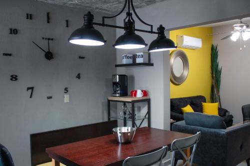 a dining room with a table and clocks on the wall at Los Flores Confort Colinas in Culiacán