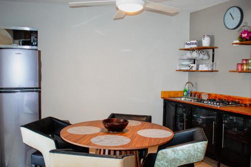 a kitchen with a wooden table and some chairs at Los Flores Confort Colinas in Culiacán