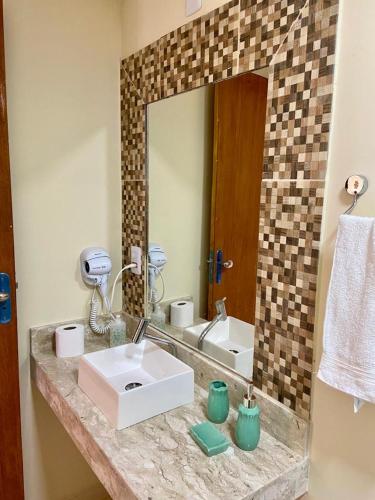 a bathroom with a sink and a mirror at Casinhas da Vila - Itacaré in Itacaré