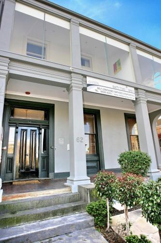 a white building with a front door and stairs at Sixty Two On Grey Serviced Apartments in Melbourne