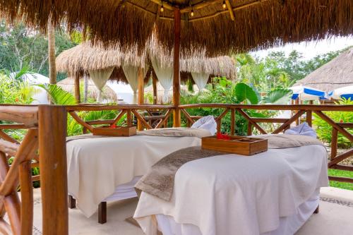 two beds under a straw umbrella in a resort at Tsaakik Jungle Hotel & Spa in Canc&uacute;n