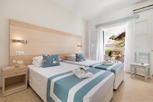 A bed or beds in a room at Iliada Beach Hotel