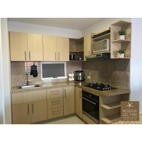 a kitchen with a sink and a stove top oven at Reserva del Mar 810 in Gaira