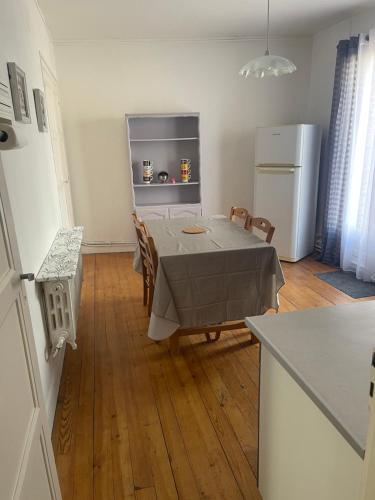 una cucina e una sala da pranzo con tavolo e frigorifero di Erliz a Noyon