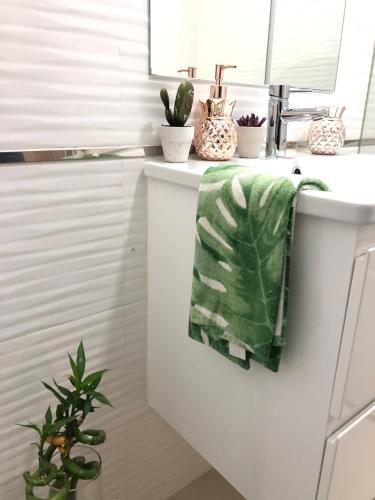 a bathroom with a green towel on a sink at Casa de Oksana in Lagos