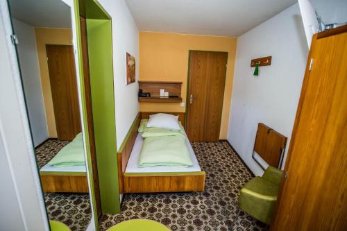 a small room with two beds and a mirror at Hotel Derby in Fiesch